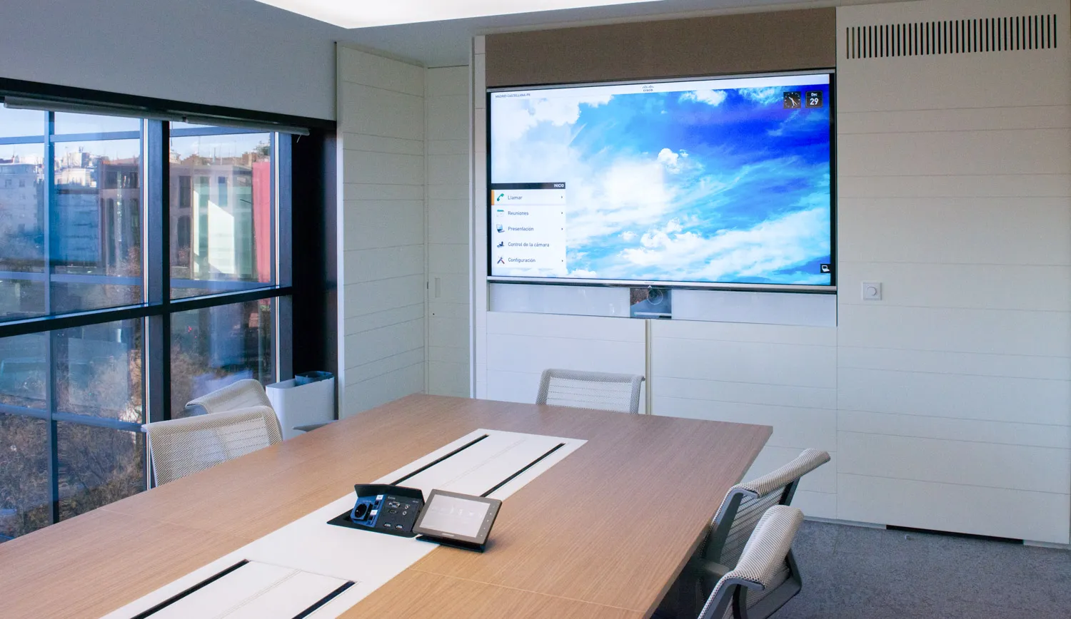 Sala de reuniones equipada con pantalla y sistema de audio integrado.